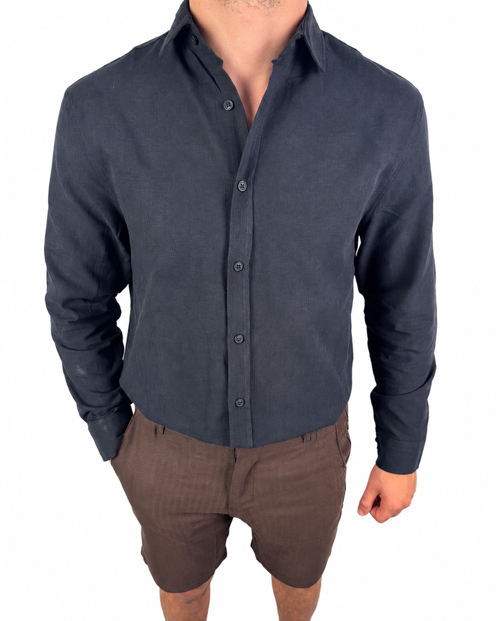 A man wearing a dark navy blue long-sleeve button-up shirt and brown shorts, shown from the neck down against a plain white background.