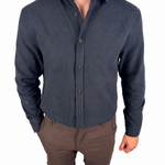 A man wearing a dark navy blue long-sleeve button-up shirt and brown shorts, shown from the neck down against a plain white background.