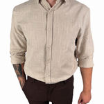 A man wearing a light beige linen long-sleeve button-down shirt and dark brown shorts, shown from the neck down against a plain white background.