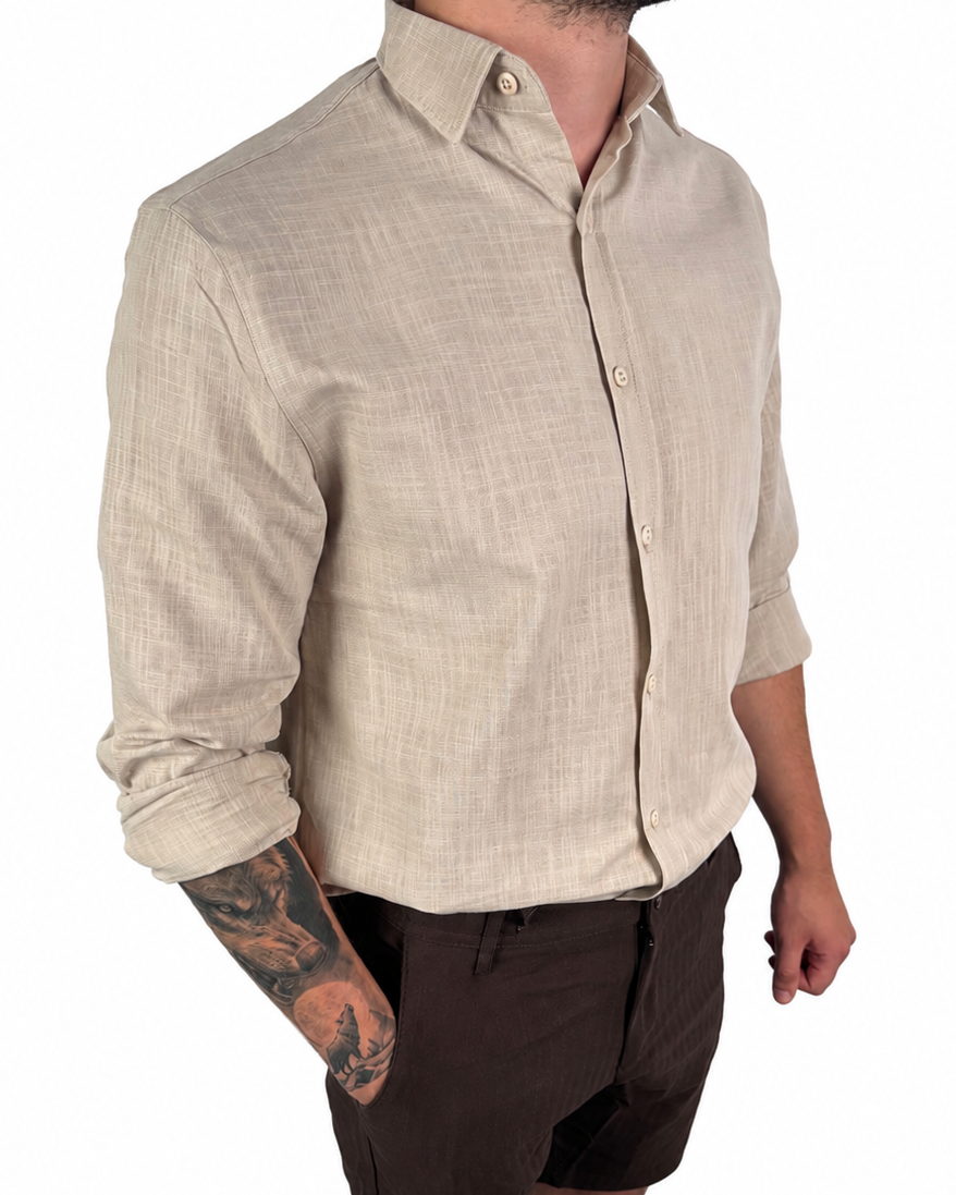 A man wearing a light beige linen button-down shirt with dark brown shorts, shown from the waist down against a plain white background.