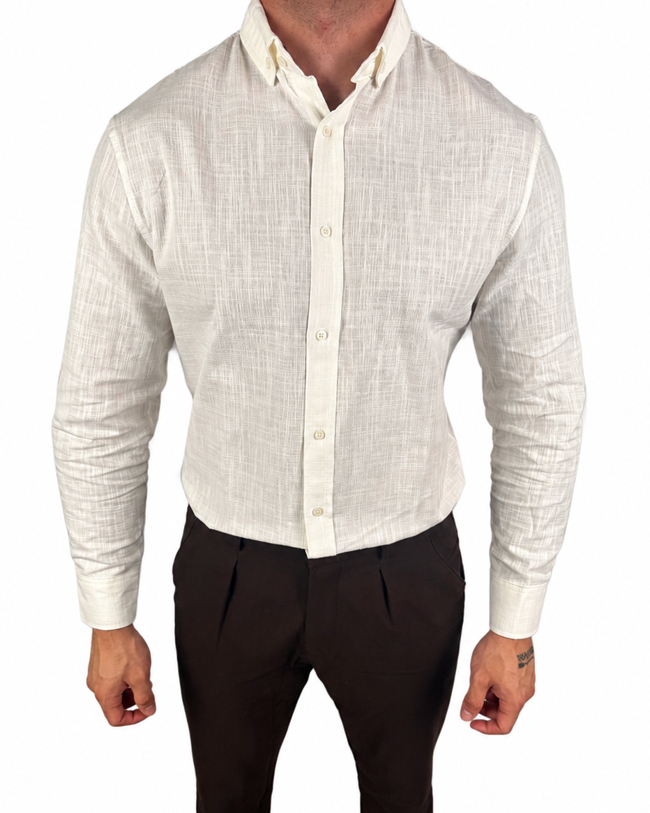 A man wearing a light beige textured linen button-down shirt and dark brown trousers, shown from the neck down against a plain white background.