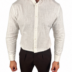 A man wearing a light beige textured linen button-down shirt and dark brown trousers, shown from the neck down against a plain white background.
