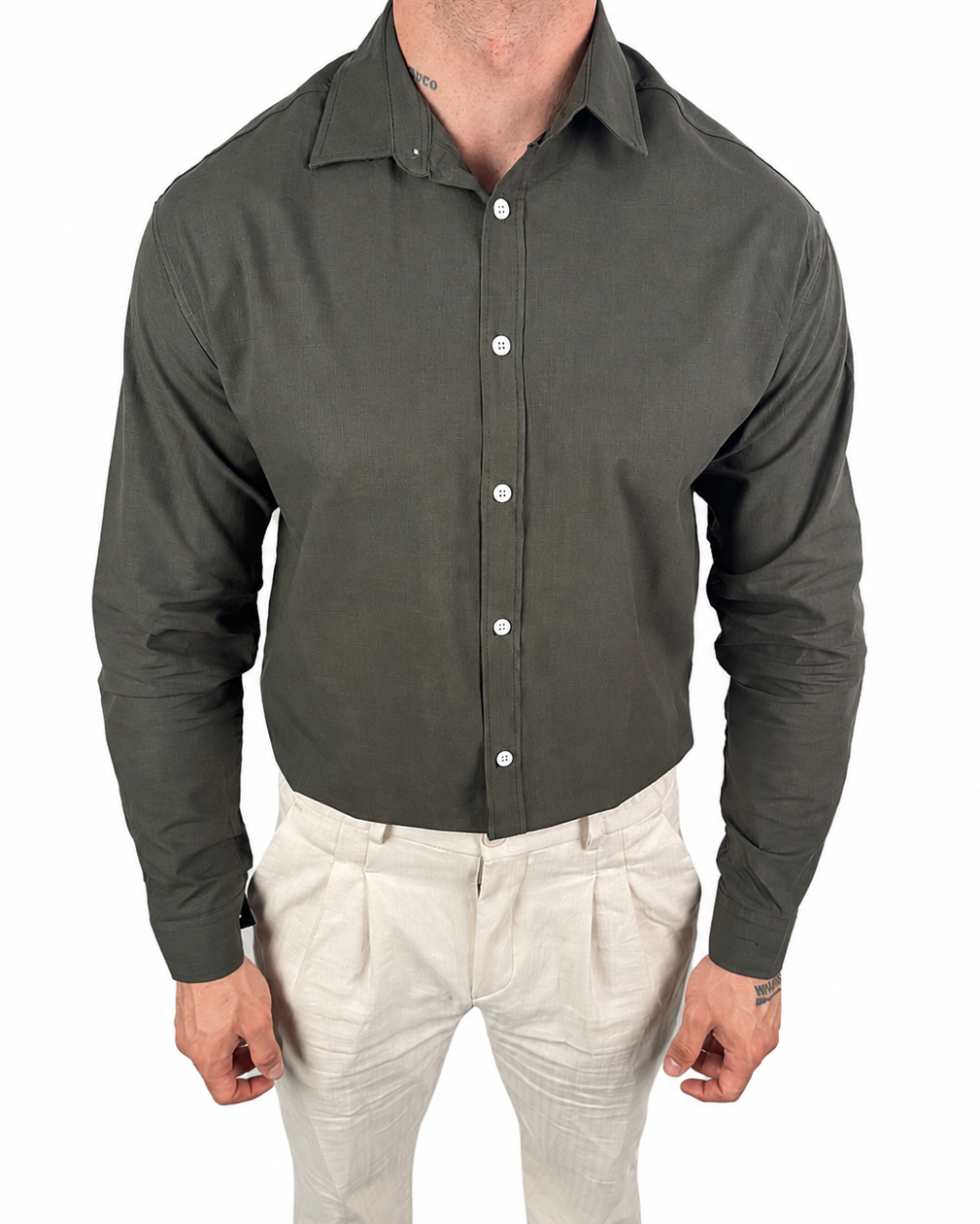A man wearing a dark olive green long-sleeve button-down shirt and light beige trousers, shown from the neck down against a plain white background.