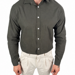 A man wearing a dark olive green long-sleeve button-down shirt and light beige trousers, shown from the neck down against a plain white background.