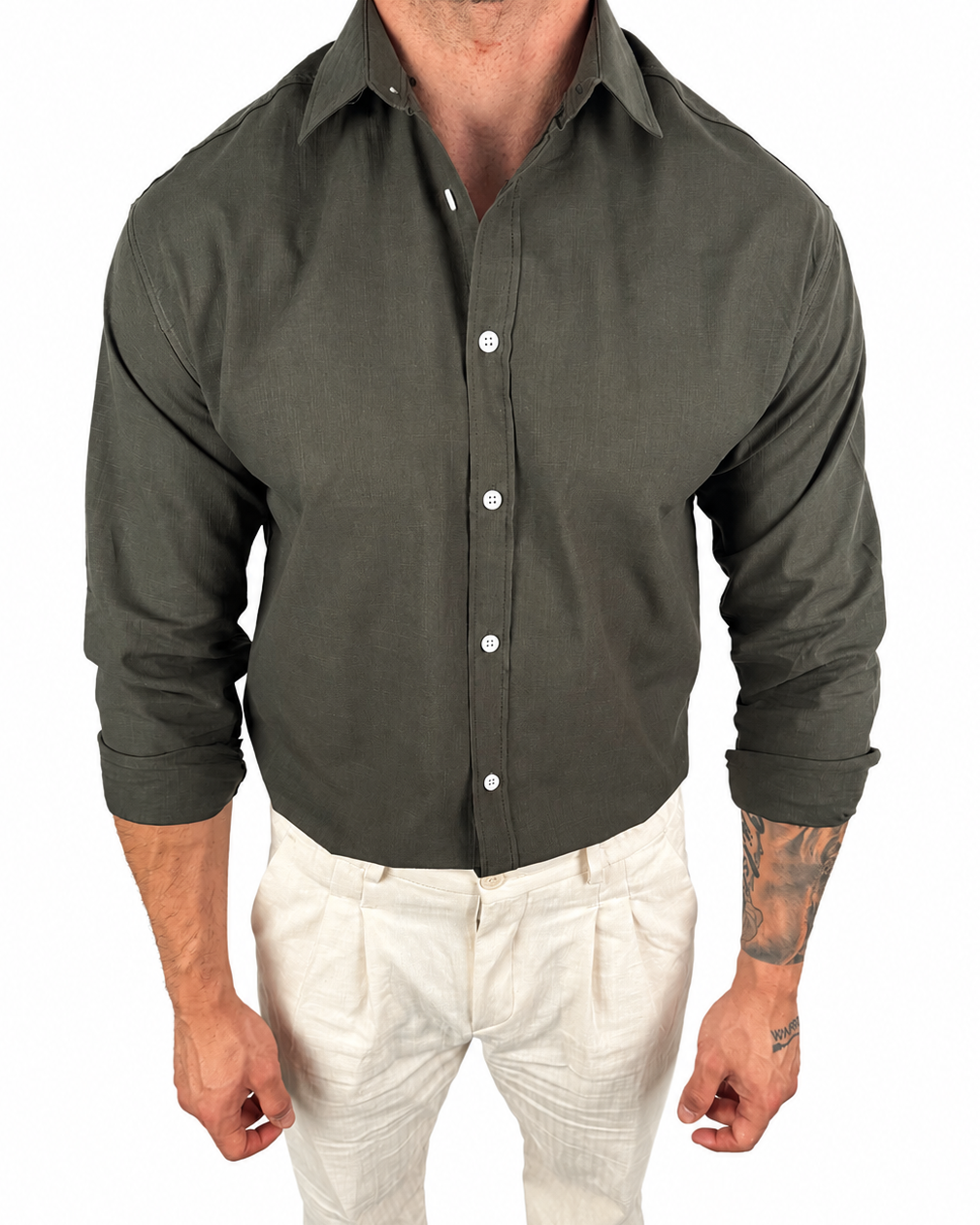 A man wearing a dark olive green long-sleeve button-down shirt and off-white trousers, shown from the neck down against a plain white background.