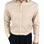 A man wearing a light beige linen long-sleeve button-down shirt and black trousers, shown from the neck down against a plain white background.