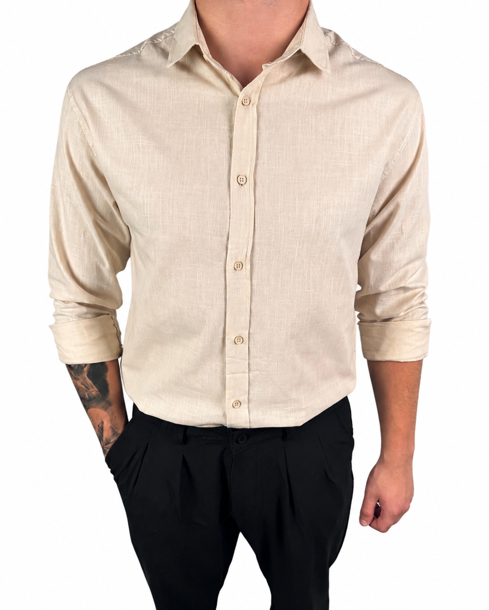 A man wearing a light beige linen button-down shirt with black trousers, shown from the neck down against a plain white background.
