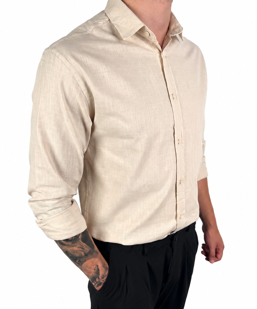 A man wearing a light beige linen button-down shirt and black trousers, shown from the neck down against a plain white background.
