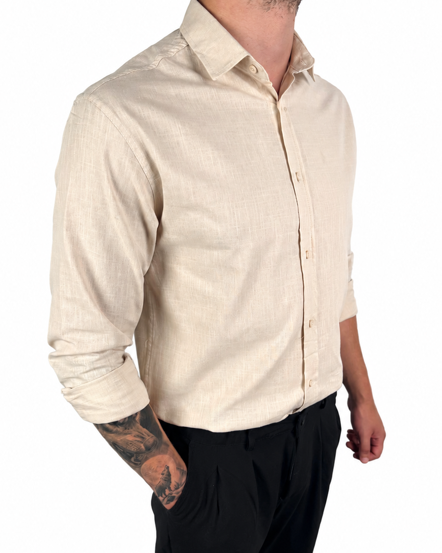 A man wearing a light beige linen button-down shirt and black trousers, shown from the neck down against a plain white background.