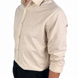 A man wearing a light beige linen button-down shirt with black trousers, shown from a side profile against a plain white background.