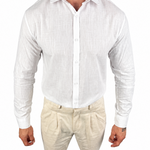 A man wearing a white long-sleeve linen button-up shirt and beige linen trousers, shown from the neck down against a plain white background.