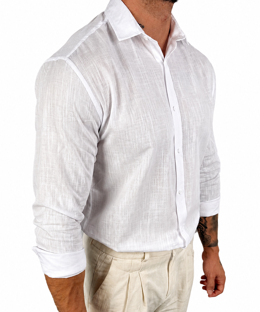A man wearing a white long-sleeve linen button-down shirt and light beige trousers, shown from the waist up against a plain white background.