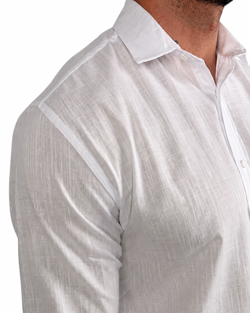 A close-up of a man wearing a white long-sleeve linen button-down shirt, showing the textured fabric and collar against a plain white background.