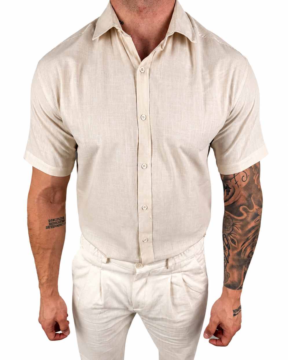 A man wearing a light beige short-sleeve linen button-up shirt and matching beige trousers, shown from the neck down against a plain white background.