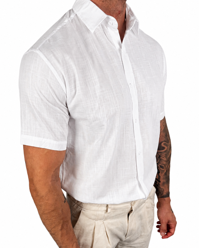 A man wearing a white short-sleeve linen button-down shirt and beige trousers, shown from the neck down against a plain white background.