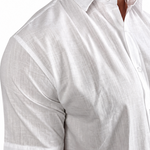 A close-up of a man wearing a white short-sleeve linen button-down shirt, showing the textured fabric and collar.