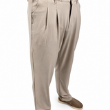 A person wearing light beige pleated trousers and brown slip-on shoes, shown from the waist down against a plain white background.