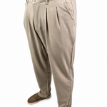 A person wearing light beige pleated trousers with brown shoes, shown from the waist down against a plain white background.