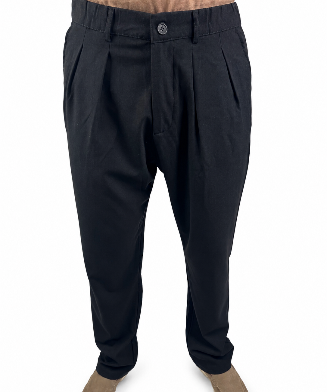 Black pleated trousers shown on a model from the waist down, paired with tan suede shoes against a plain white background.