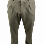 A person wearing olive green dress pants with a button closure and belt loops, paired with a brown shirt and brown shoes, shown from the waist down on a white background.