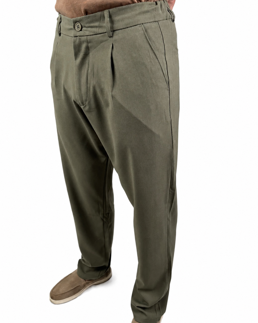 A person wearing olive green pleated trousers with a brown shirt and brown shoes, shown from the waist down against a plain white background.