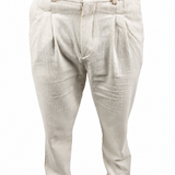 A person wearing light beige pleated trousers with a textured linen-like fabric, paired with brown shoes against a plain white background.