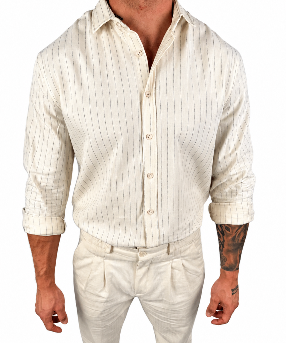 A man wearing a cream-colored linen shirt and matching trousers with thin vertical stripes, shown from the neck down against a plain white background.