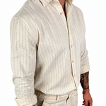 A man wearing a cream-colored linen shirt and matching linen trousers, shown from the neck down against a plain white background.
