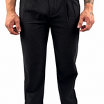 A man wearing black trousers and a white t-shirt, shown from the waist down against a plain white background.