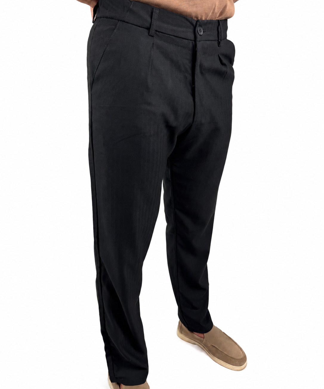 A person wearing black slim-fit dress pants with tan slip-on shoes, shown from the waist down against a plain white background.