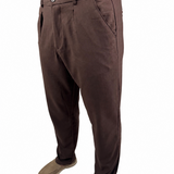 A person wearing dark brown trousers, a navy blue shirt, and tan slip-on shoes, shown from the waist down against a plain white background.