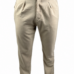 A person wearing light beige chinos or casual trousers, paired with a brown t-shirt and brown shoes, shown from the waist down against a white background.