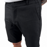 A person wearing black casual shorts with a white top, shown from the waist down against a plain white background.