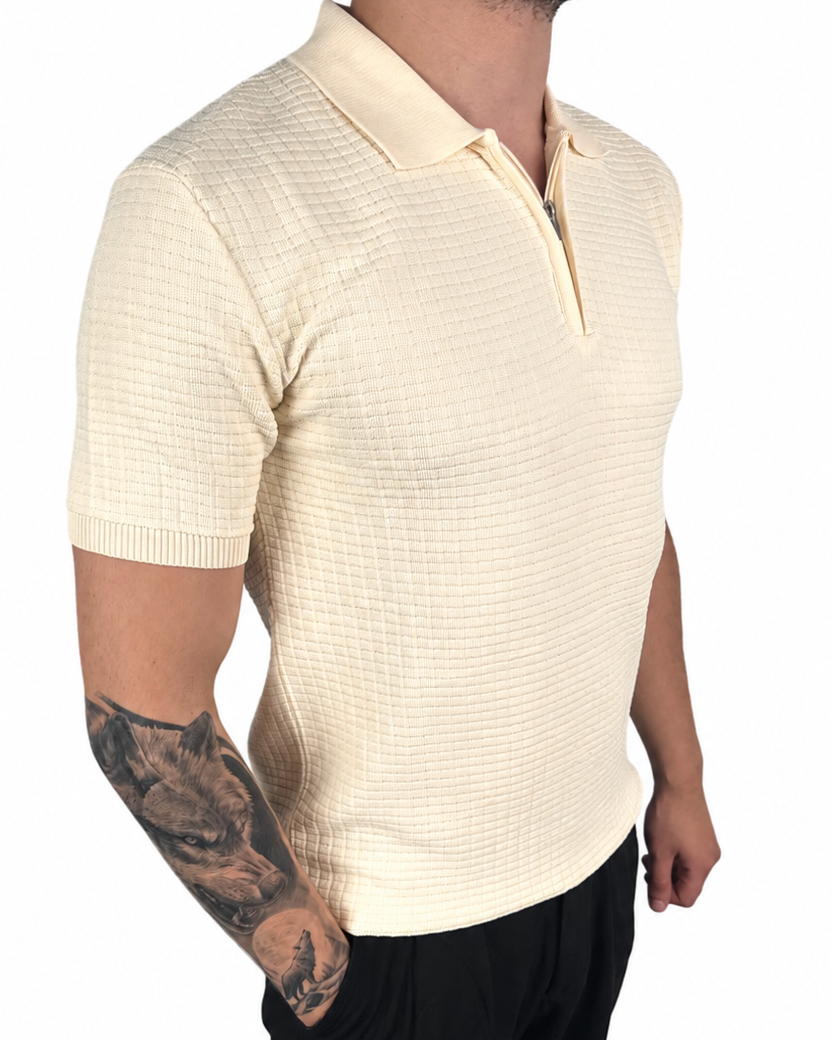 A man wearing a cream-colored short-sleeve polo shirt with a subtle grid texture, paired with black pants, shown from the side against a plain white background.