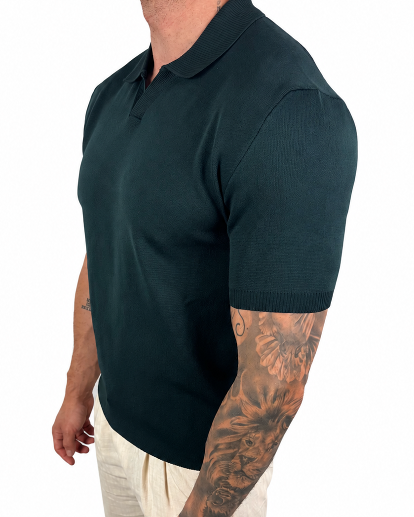 A man wearing a dark green short-sleeve polo shirt and off-white trousers, shown from a side profile against a plain white background.