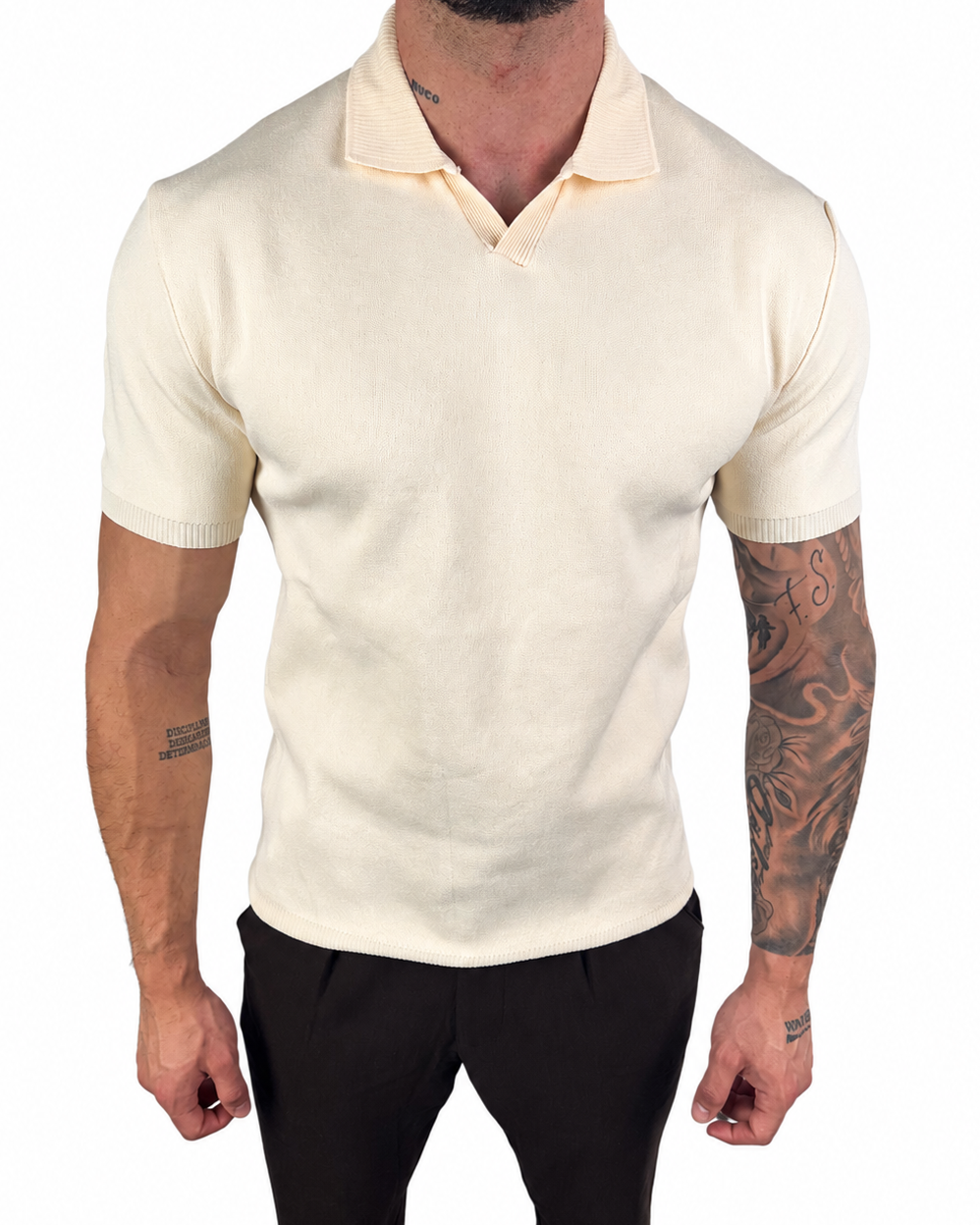 A man wearing a fitted short-sleeve knit polo shirt in cream or off-white, paired with black pants, shown against a plain white background.