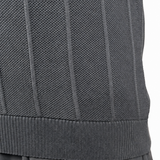 Close-up of a person wearing a dark gray ribbed knit top and dark gray pants, with the hand resting near the pocket, against a plain white background.