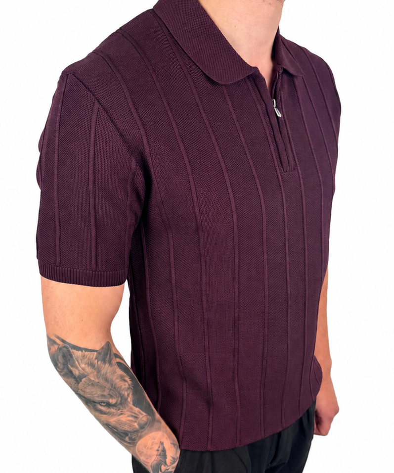 A man wearing a short-sleeve ribbed knit polo shirt in deep burgundy, paired with black trousers, shown from the waist up against a plain white background.