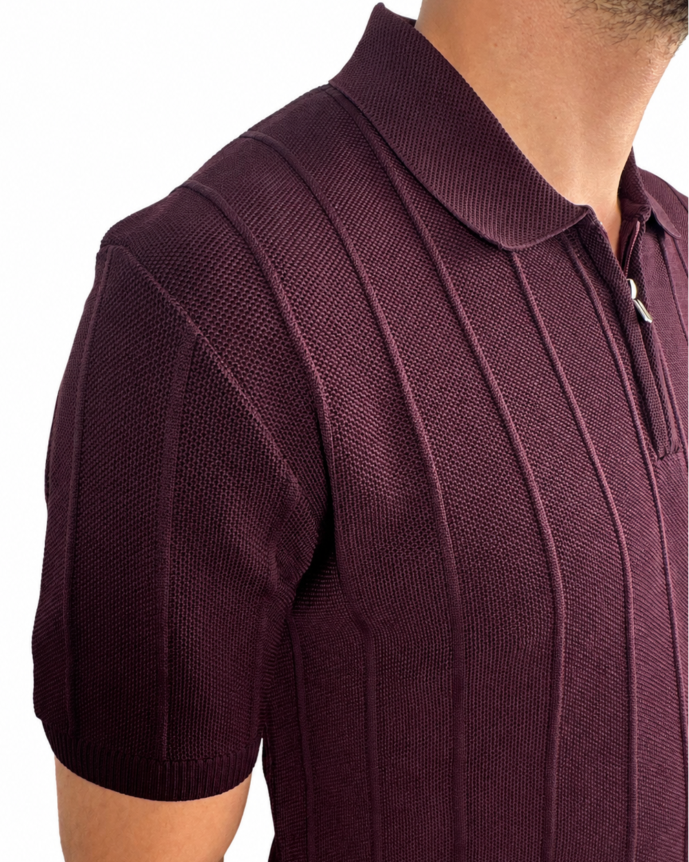 Close-up of a man wearing a short-sleeve polo shirt in deep burgundy with a textured knit pattern and a partial zip collar, shown against a plain white background.