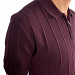 Close-up of a man wearing a short-sleeve polo shirt in deep burgundy with a textured knit pattern and a partial zip collar, shown against a plain white background.