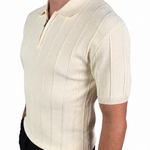 A man wearing a cream-colored short-sleeve knit polo shirt with vertical ribbed stripes and a half-zip collar, paired with black trousers, shown from a side profile against a white background.