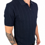 A man wearing a dark navy blue short-sleeve polo shirt with thin vertical pinstripes and a half-zip collar, paired with black pants, shown against a plain white background.