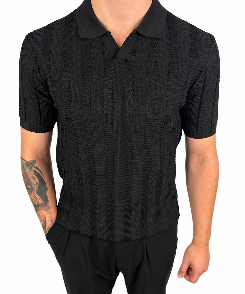 A man wearing a black short-sleeve polo shirt with a textured vertical stripe pattern and black pants, shown from the neck down against a plain white background.