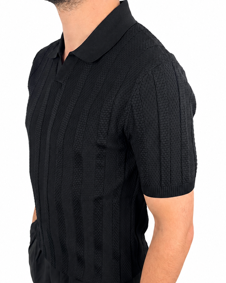 A man wearing a black short-sleeve polo shirt with a textured vertical knit pattern, shown from a side profile against a plain white background.