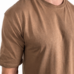 A man wearing a short-sleeve crewneck t-shirt in a washed, faded brown or tan color, shown from the neck down against a plain white background.